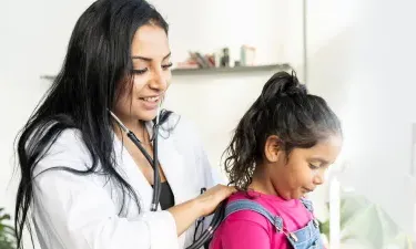 Pediatric nurse practitioner with DNP working with young patient